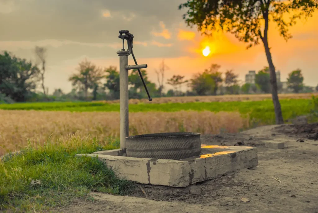 water well in field at sunset