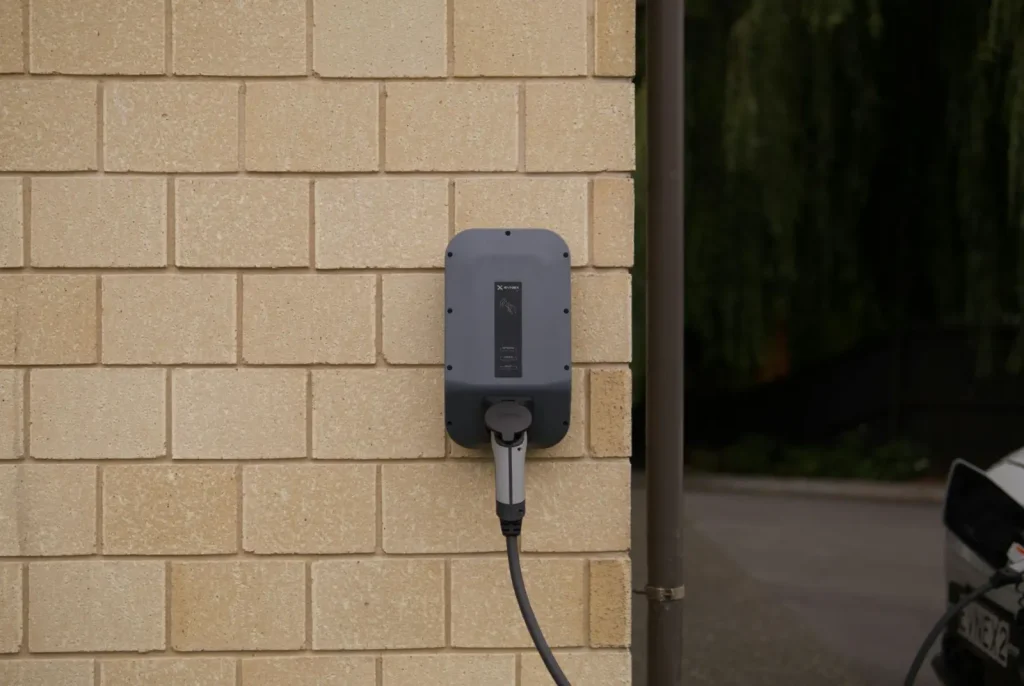 An EV charger on a brick wall.