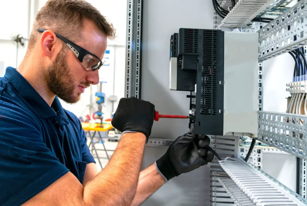 A technician repairs an electrcial panel