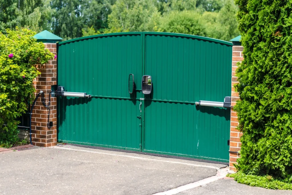 An automatic gate system with a green double door.