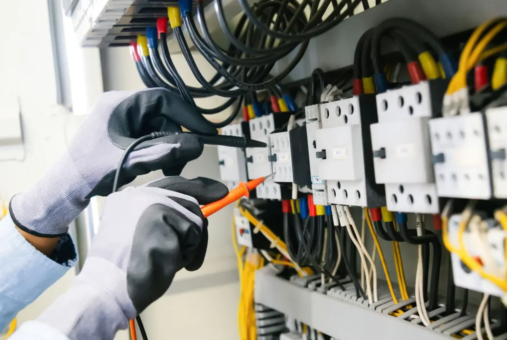 An electrician checks wires during an inspection