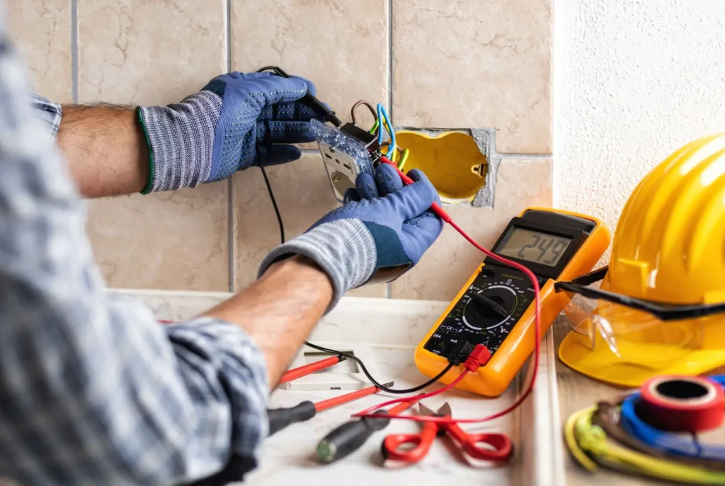 An electrician working on an outlet.