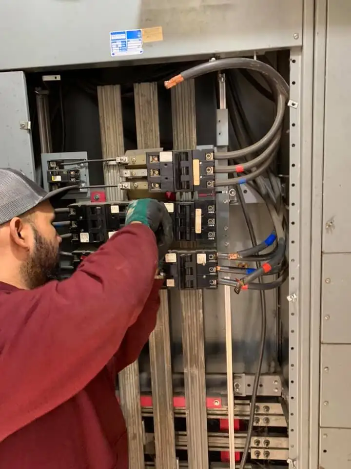 An electrician installing an electrical panel